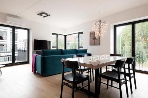 W Apartments Kalaranna III في تالين: غرفة معيشة مع طاولة وأريكة زرقاء