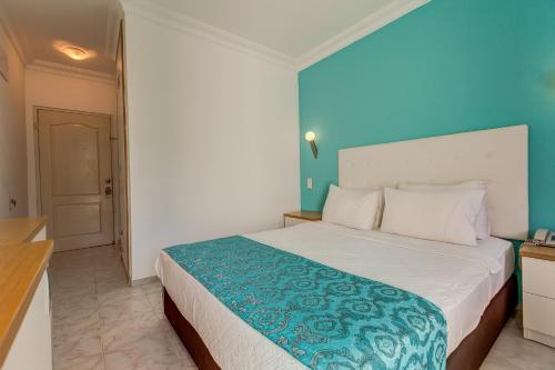 a bedroom with a large bed with a blue wall at Monta Verde Hotel & Villas in Oludeniz