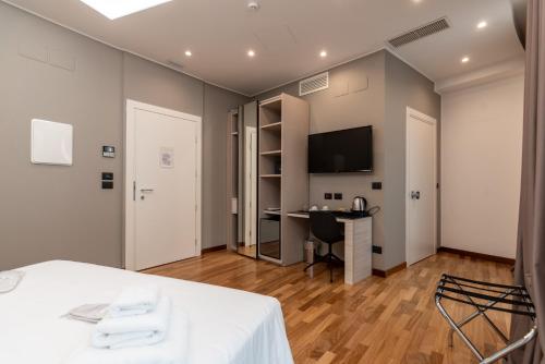 a room with a table and a desk and a tv at Sestante Marina Motel in Capo dʼOrlando