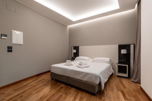 a white bedroom with a bed with white sheets and towels at Sestante Marina Motel in Capo dʼOrlando