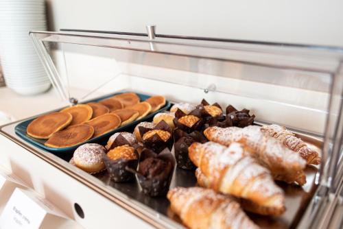 a display case filled with different types of pastries at Sestante Marina Motel in Capo dʼOrlando