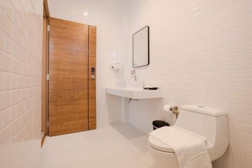 La salle de bains est pourvue de toilettes, d'un lavabo et d'une douche. dans l'établissement วิลล่ากันติ (Bed and Breakfast), à Bang Sare