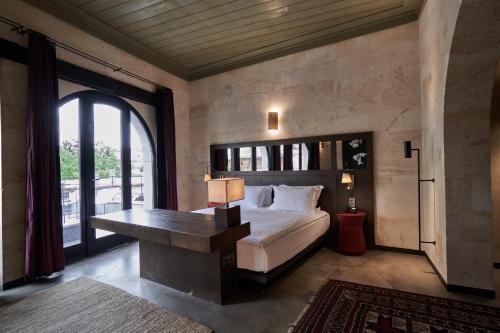 a bedroom with a bed and a large window at Carus Cappadocia in Goreme