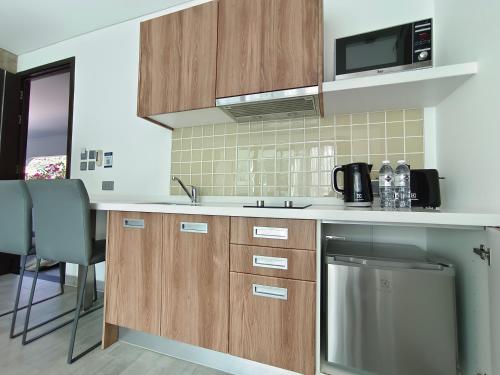 a kitchen with a sink and a microwave at Absolute Twin Sands Resort & Spa - SHA Extra Plus in Patong Beach
