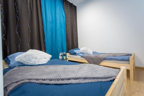 - 2 lits dans une chambre avec des draps bleus dans l'établissement Centrum red apartament, à Wałbrzych