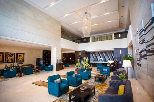 a lobby with blue chairs and tables and a library at Somerset Greenways Chennai in Chennai