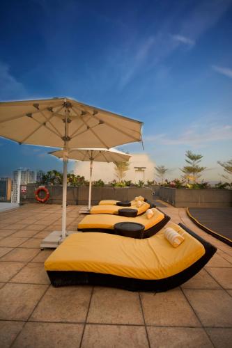 a group of four beds sitting under an umbrella at Somerset Greenways Chennai in Chennai