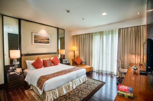 a hotel room with a large bed and a television at Somerset Greenways Chennai in Chennai