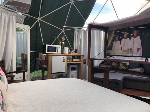 a bedroom with a tent with a tv in it at Flowerhaven - glamping dome in Hamilton