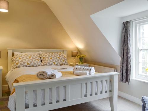 a bedroom with a white bed with towels on it at Stable Cottage in Margate