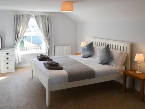 a bedroom with a white bed and a window at Riverside in Stalham