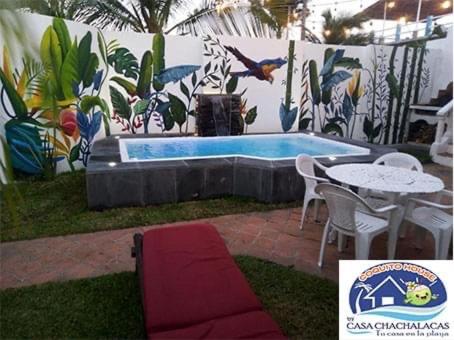 un patio con mesa, sillas y piscina en COQUITO HOUSE CHACHALACAS, en Chachalacas