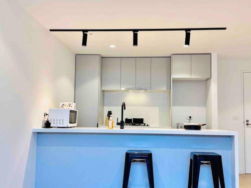 a kitchen with a blue counter and two stools at Property delisted in Highett