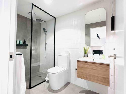 a white bathroom with a toilet and a shower at Property delisted in Highett
