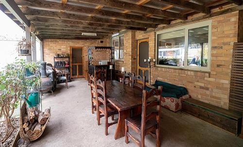 a dining room with a wooden table and chairs at Galahad's Animal Sanctuary B&B in Gisborne