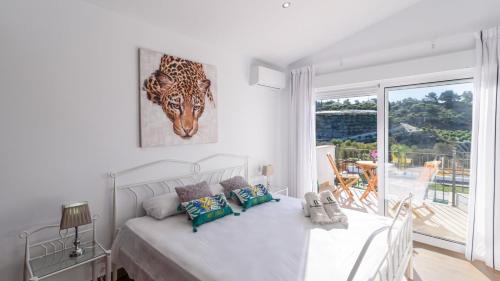 una camera bianca con un letto e una grande finestra di Villa Matella Vélez-Málaga by Ruralidays a Vélez-Málaga