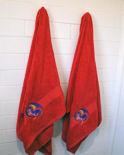 two red towels hanging on a wall in a shower at Galahad's Animal Sanctuary B&B in Gisborne