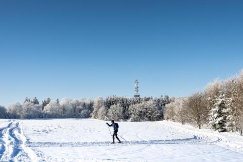 a man is cross country skiing in the snow at Hotel Monínec in Moninec