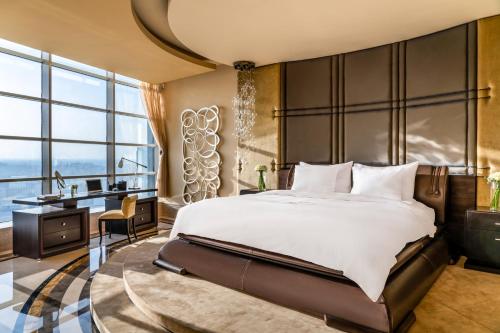 a bedroom with a large bed and a desk at La Cigale Hotel Managed by Accor in Doha