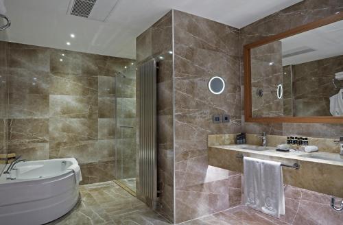 a bathroom with a tub and a sink at Dedeman Kayseri in Kayseri