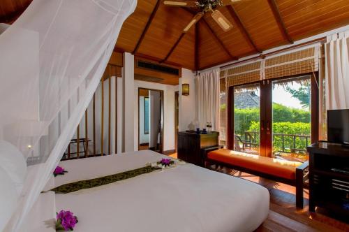 瑤亞島的住宿－Elixir Resort Koh Yao Yai - SHA Plus，一间带白色床的卧室和一个阳台