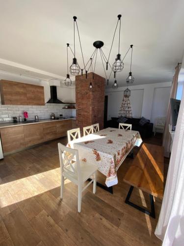 une cuisine et une salle à manger avec une table et des chaises dans l'établissement Khatuna’s apartment in villa monte, à Bakuriani