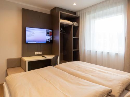 1 dormitorio con 1 cama y TV de pantalla plana en Jagerwirt rooms en Völkermarkt