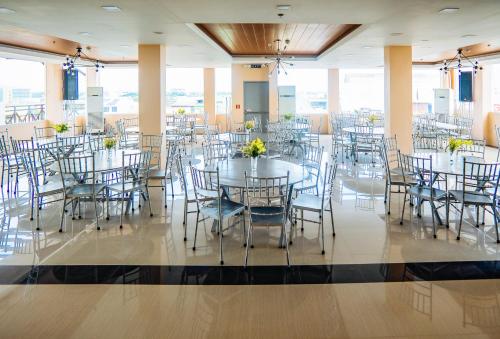 un salón de banquetes con mesas y sillas con flores en RedDoorz Plus @ Hotel Platinum Occidental Mindoro, en San José