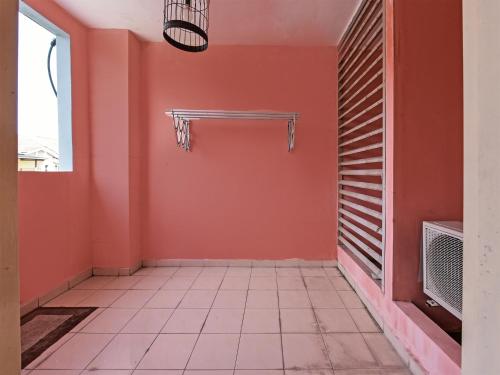 ジョホールバルにあるOYO Home 90532 Casa Azlinda Muslim Homestay Iiのオレンジの壁とバスケットボール用のフープが備わる空き部屋