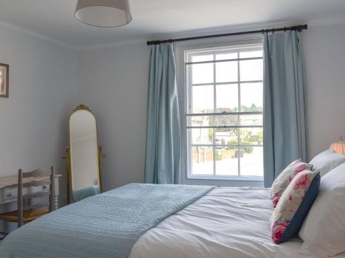 um quarto com uma cama e uma grande janela em The Townhouse em Wimborne Minster