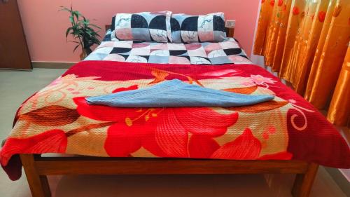 - un lit avec une couette colorée dans l'établissement REMA HOMESTAY, à Itānagar