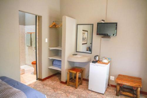 La salle de bains est pourvue d'un lavabo, de toilettes et d'une télévision. dans l'établissement Klippan River Lodge, à Groblersbrug