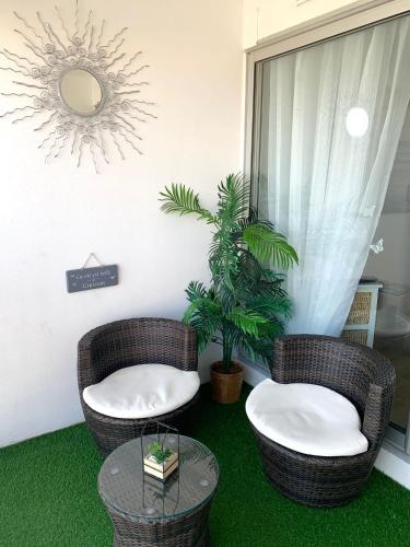 - 2 chaises en osier et une table dans une pièce dans l'établissement Cap Gruissan Vacances (11), à Gruissan