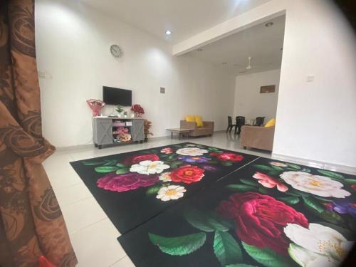 a living room with a flower carpet on the floor at HOMESTAY AT-TAQWA BATU PAHAT in Batu Pahat