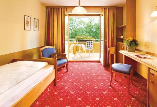 ein Hotelzimmer mit einem Bett und einem Tisch in der Unterkunft Hotel Astoria in Bad Füssing