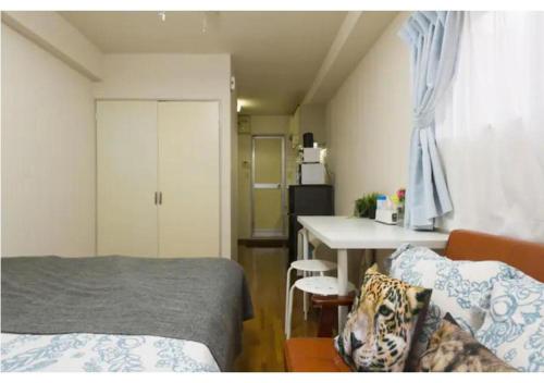 een slaapkamer met een bed en een tafel en een keuken bij Palace Mercy105 - Vacation STAY 11922 in Kugayama