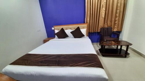 a bedroom with a large bed and a table at Hotel Abedrooms- Budget stay Thanjavur in Thanjāvūr