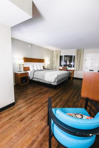 a large hotel room with a bed and a chair at The Atwood Hotel San Diego - SeaWorld/Zoo in San Diego