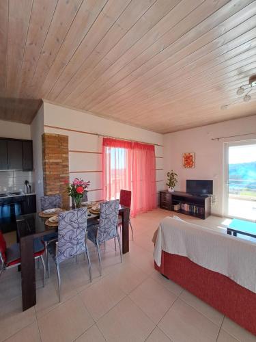 a living room with a table and chairs and a window at Vasilopoulos Estate in Koroni
