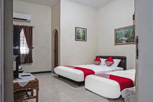 pokój hotelowy z 2 łóżkami i telewizorem w obiekcie SUPER OYO 92134 Bogor Guest House Syariah w mieście Bogor