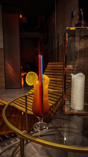 a drink on a glass table next to a mirror at Seven Hotel Bytom - Katowice in Bytom