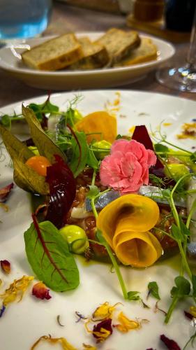 a white plate of food with flowers on it at Seven Hotel Bytom - Katowice in Bytom