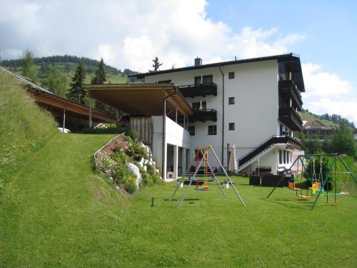 einen Hof mit einem Spielplatz vor einem Gebäude in der Unterkunft Lärchenhof Serfaus in Serfaus