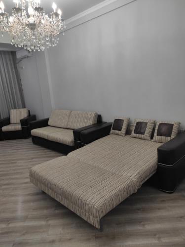 ビシュケクにあるСнять квартиру в Бишкекеのソファとシャンデリアのあるリビングルーム