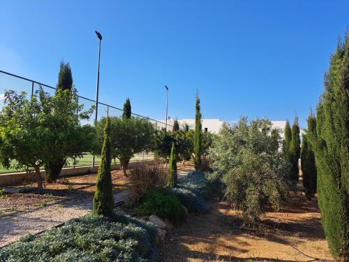 a garden with trees and bushes and a fence at Carme at the Beach - Mythical Sands in Paralimni