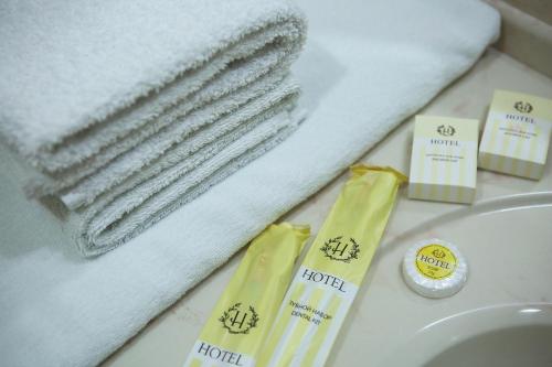 ein Badezimmer mit Handtüchern und Zahnbürsten auf einem Waschbecken in der Unterkunft Asia Hotel in Bischkek
