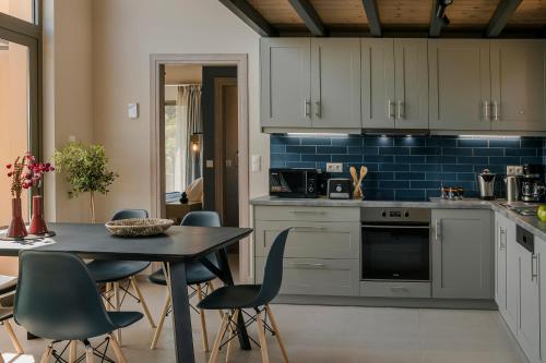 a kitchen with a table and chairs in a room at SOUND OF SEA Villas in Lixouri
