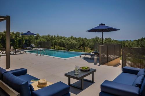 a patio with blue furniture and a swimming pool at SOUND OF SEA Villas in Lixouri