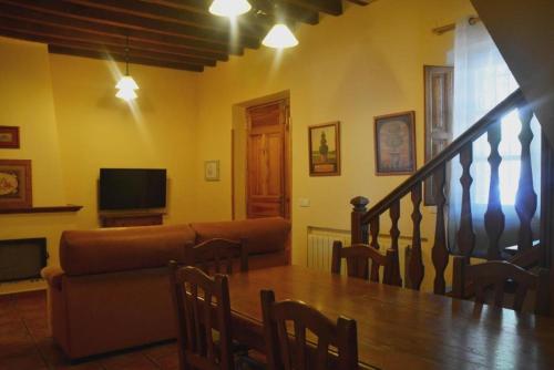 uma sala de estar com uma mesa e um sofá em Casa Rural Concejo 1 em La Adrada