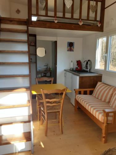 uma sala de estar com uma mesa e um sofá em Tiny des Rêves em Beulotte-Saint-Laurent